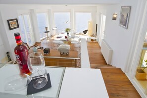 A dining area with a view of the sea, a bottle of wine, and a glass on a table. - Villa 'Blanca' with Sea View, Wi-Fi and Air Conditioning (Capdepera)