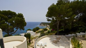 A rooftop terrace with a view of the sea, surrounded by trees and a white building. - Holiday Home 'Blanca' with Sea View, Wi-Fi and Air Conditioning (Provensals)