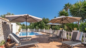 A poolside area with lounge chairs, umbrellas, and a swimming pool. - Country House 'El Amanecer' with Mountain View, Wi-Fi and Air Conditioning (Motril)