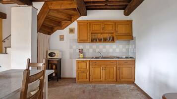 Eine Küche mit Holzausbau, gefliestem Fliesenspiegel und Steinböden.