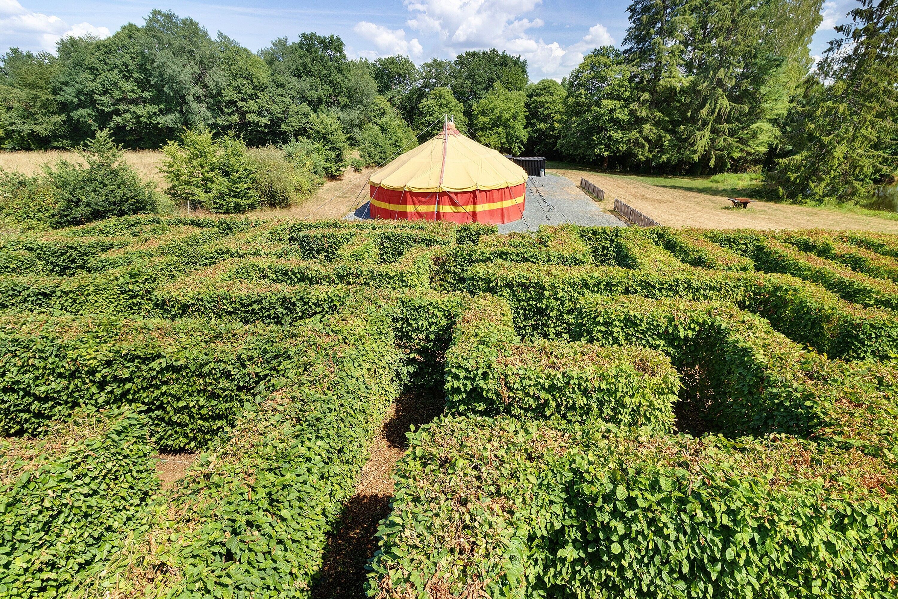 A large, open field with a central structure that appears to be a tent or pavilion.