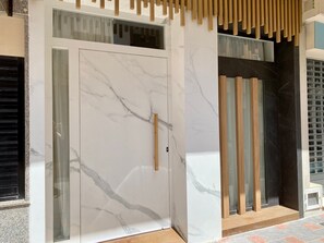 A modern entrance with a marble door, wooden panels, and a glass window. - Apartment 'Palangreros Beach' with Wi-Fi and Air Conditioning (Fuengirola)