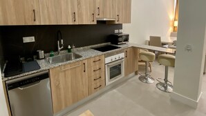 Une cuisine moderne avec des meubles en bois, un four à micro-ondes encastré, un évier et un lave-vaisselle.