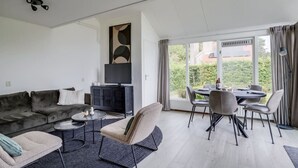 A modern living room with a sofa, coffee table, and dining area.