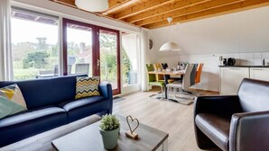 Un salon moderne comprenant un canapé, une table basse et un coin repas avec des chaises et une table.