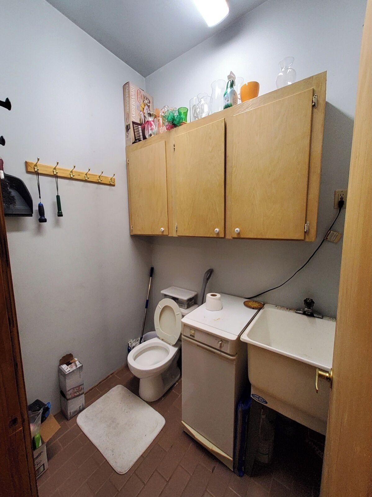 Une petite salle de bain compacte, équipée de toilettes, d’un lavabo et d’un meuble de rangement.