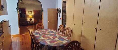 A dining area with a wooden table, chairs, and a ceiling fan.