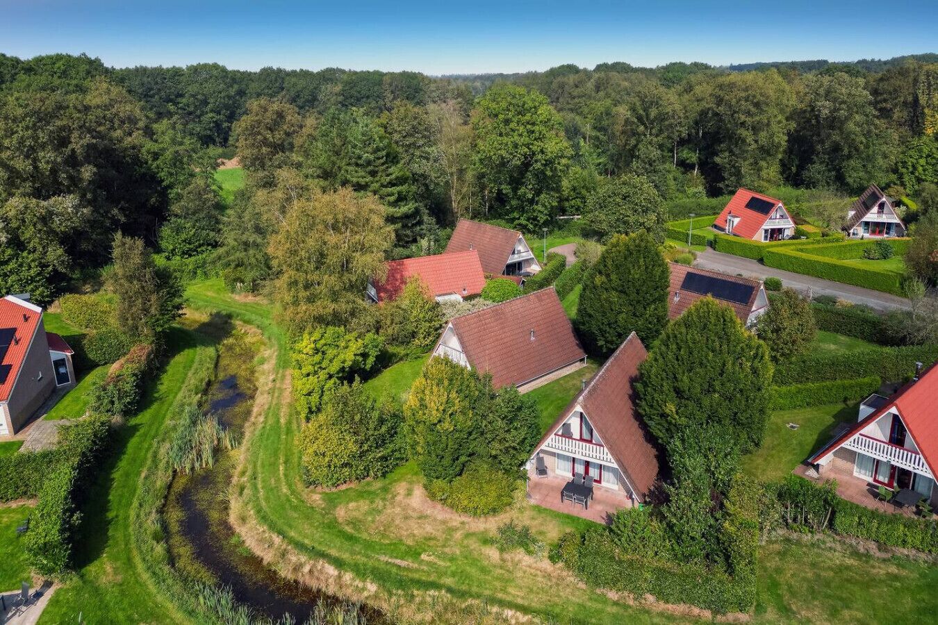 A rural village with traditional houses, a winding road, and a river.