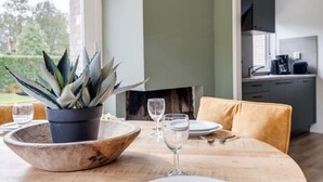 A dining table with a potted agave plant, a wooden bowl, and wine glasses. - Blue Heron I Modern Home with Fine Garden (Zwiggelte)
