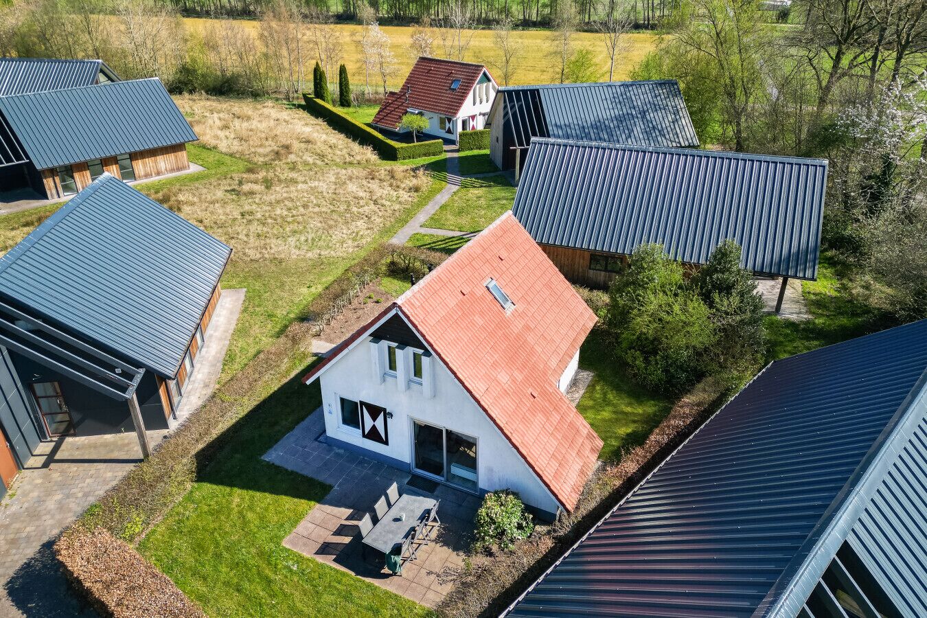 A residential area with multiple houses, each featuring a sloped roof and a mix of modern and traditional architectural styles.
