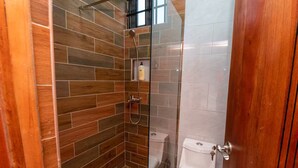 Un bagno con doccia vetrata, un water e un lavandino.