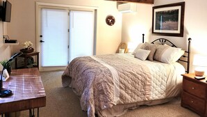 Quarto com cama, mesa de cabeceira, luminária e um quadro na parede.