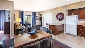 Una habitación de hotel moderna con comedor, cocina y sala de estar.