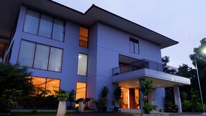 A modern two-story building with large windows, a balcony, and a well-lit entrance. - Nava Magnolia Hotel (Bandung)