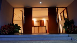 A hotel entrance with a modern design, featuring a wooden facade and glass doors. - Nava Magnolia Hotel (Bandung)