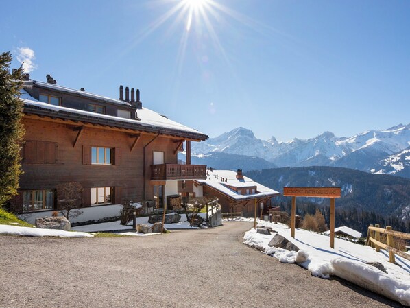 A wooden lodge with a balcony, a sign reading 'Residence Martin Gaipe A.D.', and a mountain view.