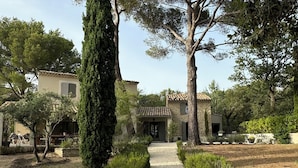 A gravel pathway leading to a stone building with a tiled roof, surrounded by greenery and trees. - Charming 4-bedroom Villa with AC, WiFi in lovely L'Isle-sur-la-Sorgue (L'Isle-sur-la-Sorgue)