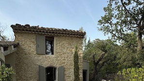 A stone house with a gravel courtyard, a bench, and a table. - Charming 4-bedroom Villa with AC, WiFi in lovely L'Isle-sur-la-Sorgue (L'Isle-sur-la-Sorgue)
