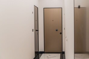 A hallway with a closed door, a light switch, and a marble floor. - Elegant 49 sqm apartment in the prestigious Palazzo Machiavelli, located in the heart of Trieste. Perfect for 4 guests, it is situated on the second floor of a building with an elevator (not suitable for disabled individuals). The location is excellent,  (Trieste)