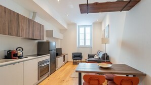 Una cocina moderna con comedor, armarios de madera, una estufa y una mesa con sillas.