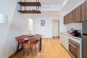Una cocina moderna con armarios de madera, una mesa de comedor con sillas y una lámpara colgante.