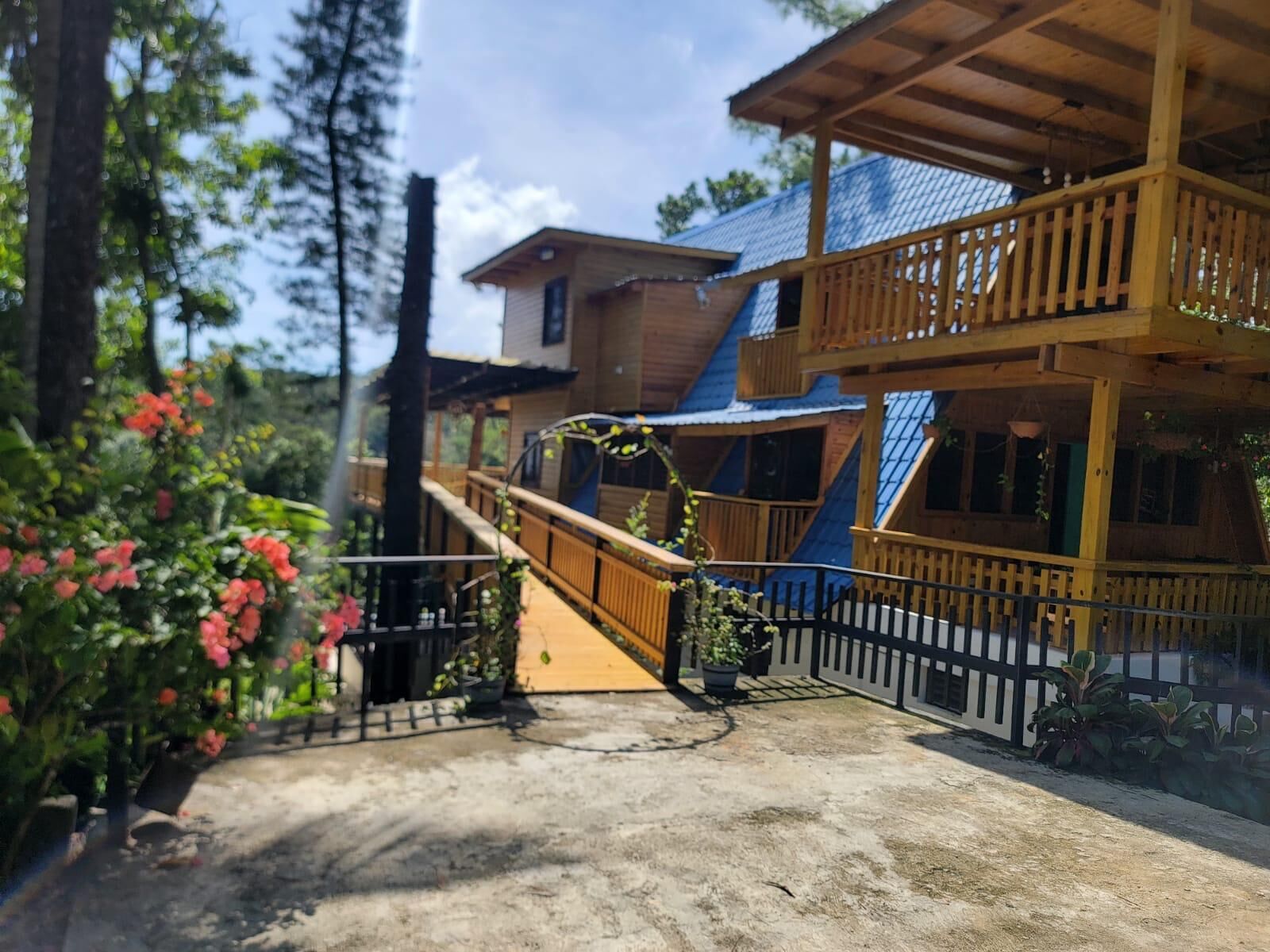 A wooden cabin with a balcony and a staircase leading to the upper level.