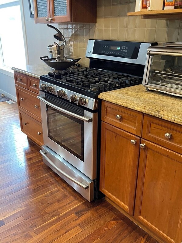 A kitchen with a stainless steel stove, oven, and a built-in toaster.