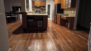 Een moderne keuken met houten kasten, een centraal eiland en geïntegreerde apparatuur.