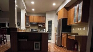 Een moderne keuken met houten kastjes, een centraal eiland en inbouwapparatuur.