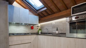 Una cocina moderna con armarios de madera, horno empotrado y tragaluz.