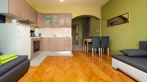 Une cuisine moderne avec des meubles en bois, un four encastré et un coin repas comprenant une table et des chaises.