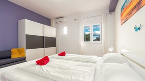A hotel room with two beds, a wardrobe, a window with a view, and a painting on the wall. - Apartment Julia A5, 2+2 (Biograd na moru)