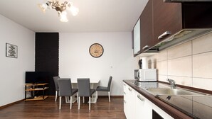 A modern kitchen with a dining area, a clock, and a television. - Apartment Julia A5, 2+2 (Biograd na moru)