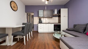 A modern living space with a dining area, kitchen, and seating area. - Apartment Julia A5, 2+2 (Biograd na moru)