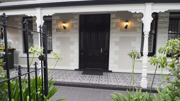 Una casa con puerta negra, número 45, y dos luces fijadas a la pared.
