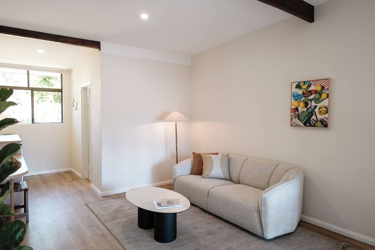 Una sala de estar moderna con un sofá, una mesa de centro y una lámpara.