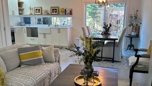 A modern living room with a sofa, coffee table, and dining area. - Charming country home in beautiful Pt Grey Village. Close to Beach, UBC, DT.  (Vancouver)
