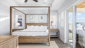 Un dormitorio con cama con dosel, mesita de noche, lámpara y ventana con persianas.