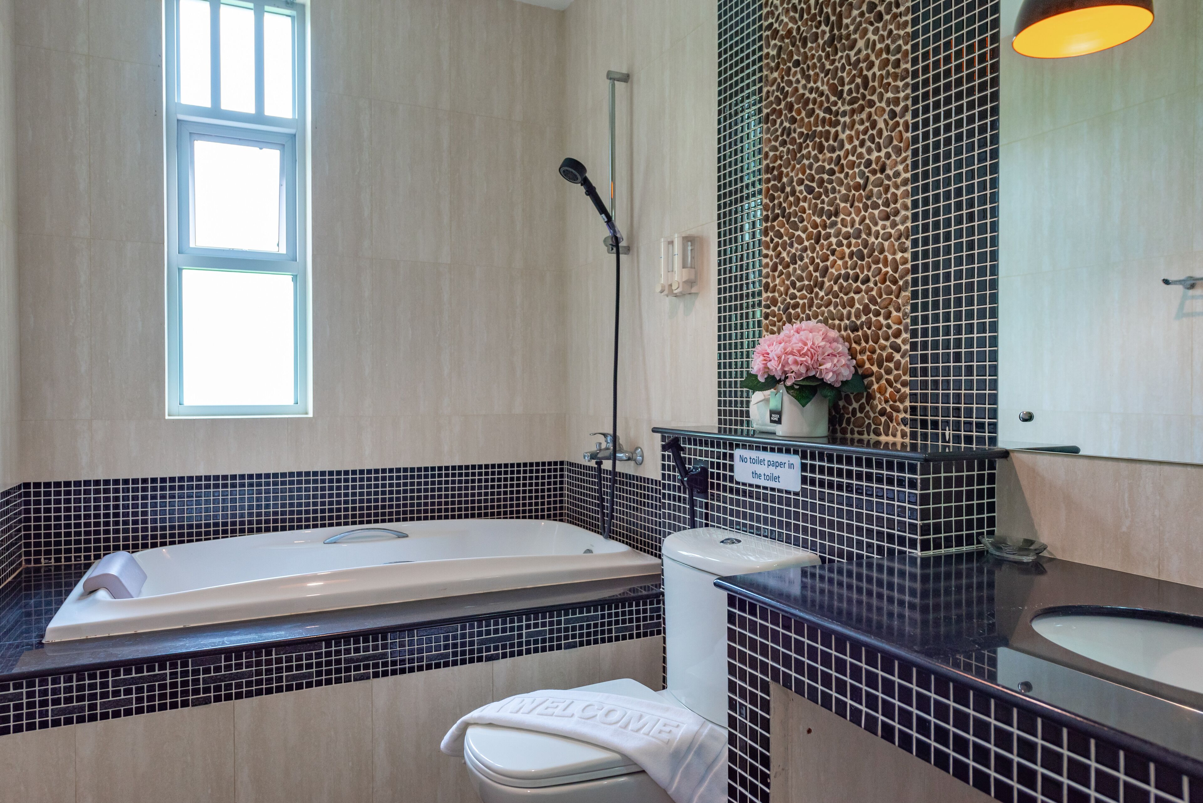 A modern bathroom with a bathtub, toilet, and sink.