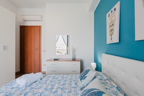 A bedroom with a bed, a dresser, a mirror, and a door.