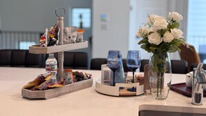 Una hall d'albergo con un tavolo per il buffet, un vaso di fiori bianchi e un'area relax sullo sfondo.
