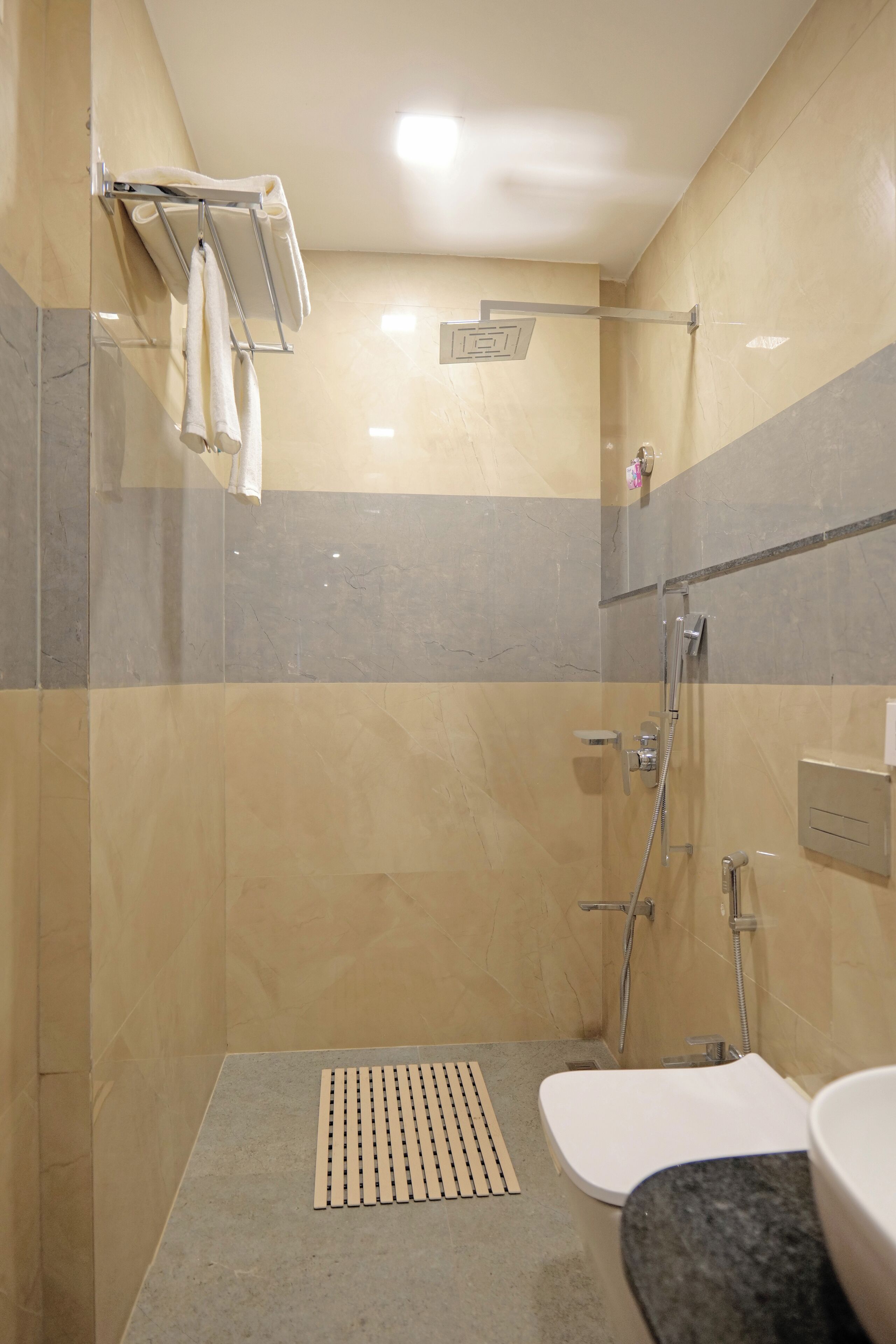 A modern bathroom with a shower, toilet, and sink.