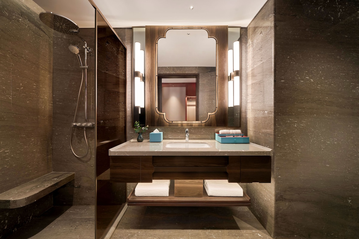 A modern bathroom with a shower, a sink, and a vanity.