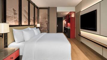 Habitación de hotel moderna con una cama grande, un televisor de pantalla plana y un armario rojo.