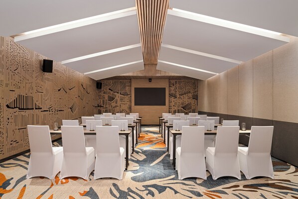 A conference room with white chairs, a patterned carpet, and a modern ceiling design. - Dusit Le Palais Tu Hoa Hanoi (Hanoi)