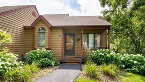 A two-story house with a front porch, a small entryway, and a mailbox. - 2 Bedroom, beautiful end unit (Galena)