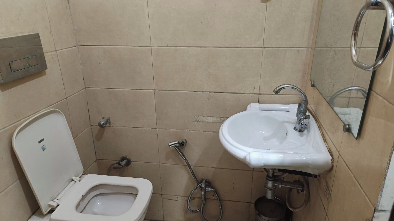 A small bathroom with a toilet, a sink, and a shower.