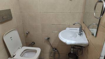 A small bathroom with a toilet, a sink, and a shower.