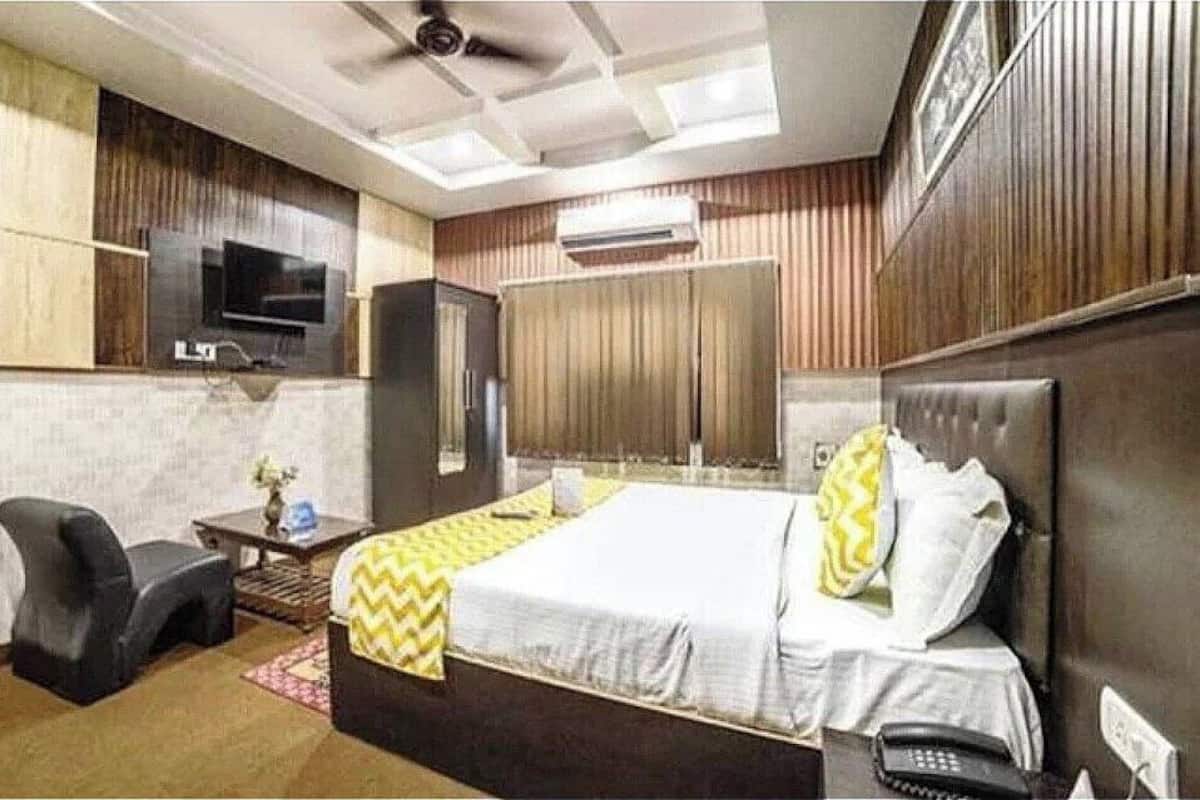 Une chambre d’hôtel équipée d’un lit, d’un bureau, d’une chaise, d’une télévision et d’un appareil de climatisation.