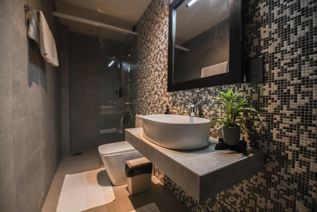 Un baño moderno con un lavabo grande, un espejo y una ducha.